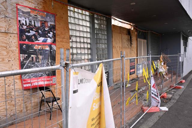 Banners and flowers hang from a security fence outside the torched Adass Israel Synagogue in Melbourne on February 12, 2026. Israel’s President Isaac Herzog was scheduled to visit the synagogue during his visit to Melbourne, but the event was cancelled. Herzog's tightly secured, four-day trip aims to console Australia's Jewish community after the December shooting at Sydney's Bondi Beach that killed 15 people at a Hanukkah festival. (Photo by WILLIAM WEST / AFP)