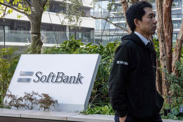 A man walks outside the headquarters of Japanese company SoftBank Group in Tokyo on February 12, 2026. (Photo by Yuichi YAMAZAKI / AFP)
