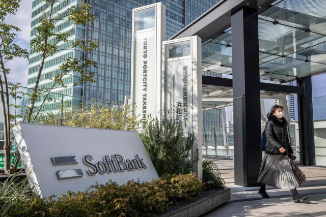 A woman walks outside the headquarters of Japanese company SoftBank Group in Tokyo on February 12, 2026. (Photo by Yuichi YAMAZAKI / AFP)