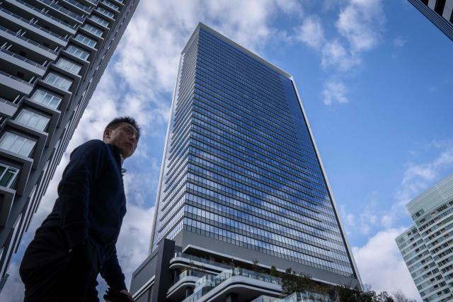 A man walks past Japan's SoftBank Group headquarters building in Tokyo on February 12, 2026. (Photo by Yuichi YAMAZAKI / AFP)