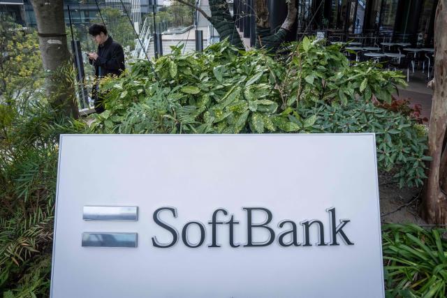 A man walks outside the headquarters of Japanese company SoftBank Group in Tokyo on February 12, 2026. (Photo by Yuichi YAMAZAKI / AFP)