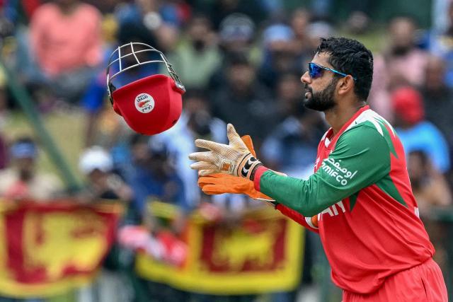 Oman's Vinayak Shukla collects his helmet during the 2026 ICC Men's T20 Cricket World Cup group stage match between Sri Lanka and Oman at the Pallekele International Cricket Stadium in Kandy on February 12, 2026. (Photo by Ishara S. KODIKARA / AFP)