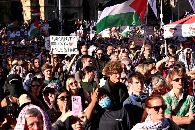 Protesters hold placards and flags outside Flinders Street station during the visit of Israel’s President Isaac Herzog in Melbourne on February 12, 2026. Herzog's tightly secured, four-day trip aims to console Australia's Jewish community after the December shooting at Sydney's Bondi Beach that killed 15 people at a Hanukkah festival. (Photo by WILLIAM WEST / AFP)