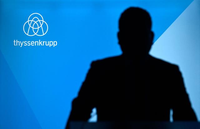 (FILES) Thyssenkrupp CEO Miguel Angel Lopez Borrego silhouettes against a wall with his company's logo as he arrive to address the annual news conference of German industrial titan Thyssenkrupp at the company's headquarters in Essen, western Germany on December 9, 2025. German industrial group Thyssenkrupp said on February 12, 2026 that it had sunk to a loss as it feels the effects of a prolonged slump. The firm, which has interests in sectors ranging from steel to car parts to submarines, lost 353 million euros ($419 million) in the first quarter, compared to a loss of 51 million euros this time last year. (Photo by Ina FASSBENDER / AFP)