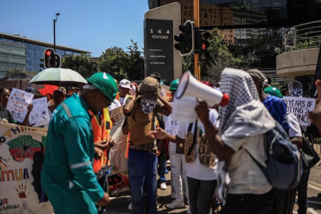 Members of South Africa's mining affected communities react during their protest outside Anglo American's headquarters in Johannesburg on February 12, 2026. Protesters are demanding full accountability before Anglo American exits South Africa, including rehabilitation, outstanding social obligations and transparency on liabilities. (Photo by Phill Magakoe / AFP)