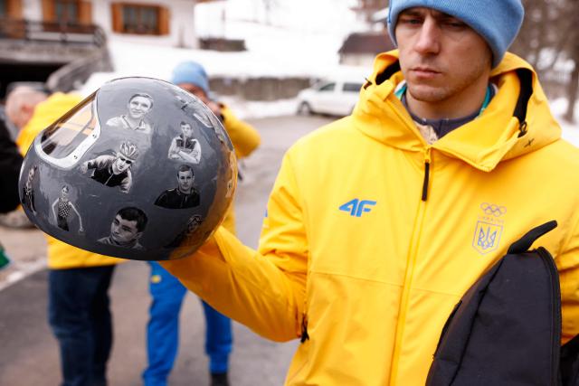 Ukraine's skeleton racer Vladyslav Heraskevych holds his helmet, which depicts victims of his country's war with Russia, in Cortina d'Ampezzo on February 12, 2026. Heraskevych was disqualified from the Winter Olympics on February 12, 2026 after refusing to back down over his banned helmet, which depicts victims of his country's war with Russia.
The International Olympic Committee said he had been kicked out of the Milan-Cortina Games "after refusing to adhere to the IOC athlete expression guidelines". (Photo by Odd ANDERSEN / AFP)