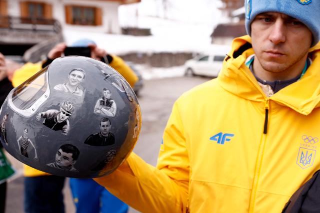 Ukraine's skeleton racer Vladyslav Heraskevych holds his helmet, which depicts victims of his country's war with Russia, in Cortina d'Ampezzo on February 12, 2026. Heraskevych was disqualified from the Winter Olympics on February 12, 2026 after refusing to back down over his banned helmet, which depicts victims of his country's war with Russia.
The International Olympic Committee said he had been kicked out of the Milan-Cortina Games "after refusing to adhere to the IOC athlete expression guidelines". (Photo by Odd ANDERSEN / AFP)