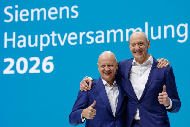 Siemens CEO Roland Busch (R) and CFO Ralf Thomas pose before the annual general shareholders meeting of industrial giant Siemens in Munich, southern Germany, on February 12, 2026. German industrial giant Siemens on February 12, 2026 raised its outlook for the year after a strong first quarter boosted by spending on artificial intelligence. (Photo by Michaela STACHE / AFP)