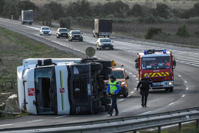 A truck lies on its side during strong winds brought by storm Nils near Leucate, southwesten France on February 12, 2026. Accompanied by winds exceeding 160 km/h, Storm Nils swept across several regions of France on February 12, 2026, causing the death of a lorry driver in the Landes and damage, leaving 850,000 homes without electricity, particularly in the southwest. (Photo by Ed JONES / AFP)