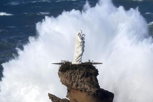 TOPSHOT - Waves crash at the Rock of the Virgin (Rocher de la Vierge) in Biarritz, southwestern France on February 12, 2026, as storm Nils hits the area. Accompanied by winds exceeding 160 km/h, Storm Nils swept across several regions of France on February 12, 2026, causing the death of a lorry driver in the Landes and damage, leaving 850,000 homes without electricity, particularly in the southwest. (Photo by Gaizka IROZ / AFP)