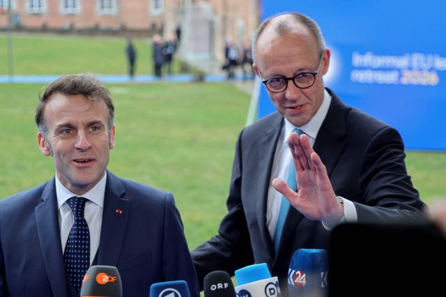 France's President Emmanuel Macron (L) and Germany's Chancellor Friedrich Merz speak to the press upon their arrival to take part in the Informal EU Leaders' Retreat at the Alden Biesen Castle in Alden Biesen, central Belgium on February 12, 2026. (Photo by Ludovic MARIN / AFP)