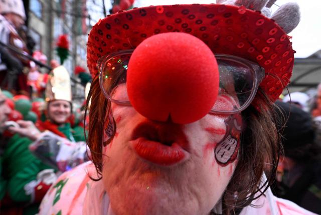 A woman dressed as a clown poses at the start of the carnival season during the Women's Carnival Day in Cologne, western Germany on February 12, 2026. The festivities begin with "Weiberfastnacht", a raucous street party in which women snip off men's ties. (Photo by INA FASSBENDER / AFP)