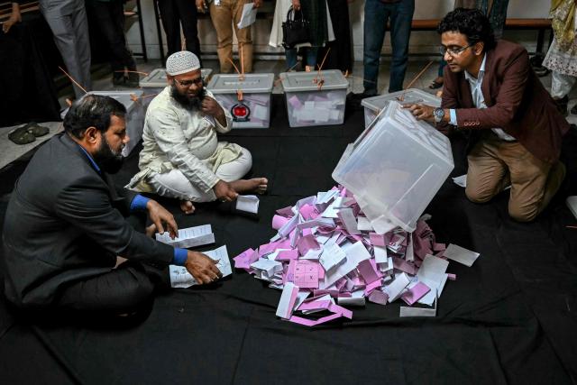 An electoral official opens a ballot box as counting starts at a polling station during Bangladesh's general election in Dhaka on February 12, 2026. Counting began on February 12 in Bangladesh's first election since a deadly 2024 uprising, with powerful political heir Tarique Rahman bullish about defeating an Islamist-led coalition. (Photo by Sajjad HUSSAIN / AFP)
