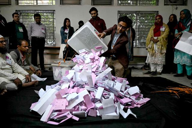 An electoral official opens a ballot box as counting starts at a polling station during Bangladesh's general election in Dhaka on February 12, 2026. Counting began on February 12 in Bangladesh's first election since a deadly 2024 uprising, with powerful political heir Tarique Rahman bullish about defeating an Islamist-led coalition. (Photo by Sajjad HUSSAIN / AFP)
