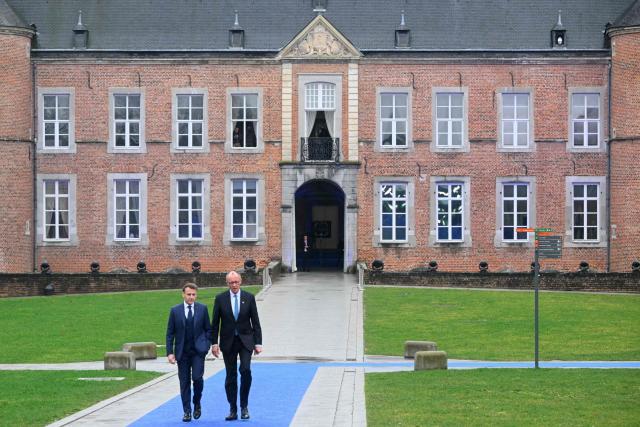 France's President Emmanuel Macron (L) and Germany's Chancellor Friedrich Merz arrive to attend the Informal EU Leaders' Retreat at the Alden Biesen Castle in Alden Biesen, central Belgium on February 12, 2026. (Photo by NICOLAS TUCAT / AFP)