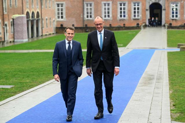France's President Emmanuel Macron (L) and Germany's Chancellor Friedrich Merz arrive to attend the Informal EU Leaders' Retreat at the Alden Biesen Castle in Alden Biesen, central Belgium on February 12, 2026. (Photo by NICOLAS TUCAT / AFP)