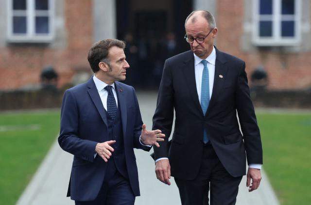 France's President Emmanuel Macron (L) and Germany's Chancellor Friedrich Merz arrive to attend the Informal EU Leaders' Retreat at the Alden Biesen Castle in Alden Biesen, central Belgium on February 12, 2026. (Photo by Ludovic MARIN / AFP)