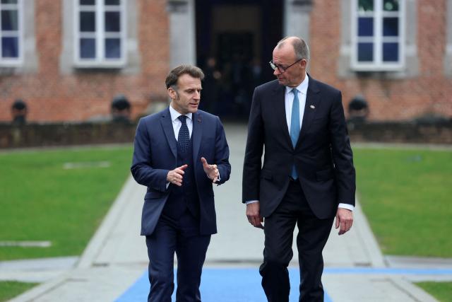 France's President Emmanuel Macron (L) and Germany's Chancellor Friedrich Merz arrive to attend the Informal EU Leaders' Retreat at the Alden Biesen Castle in Alden Biesen, central Belgium on February 12, 2026. (Photo by Ludovic MARIN / AFP)