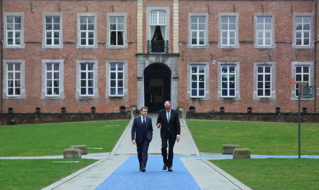 France's President Emmanuel Macron (L) and Germany's Chancellor Friedrich Merz arrive to attend the Informal EU Leaders' Retreat at the Alden Biesen Castle in Alden Biesen, central Belgium on February 12, 2026. (Photo by Ludovic MARIN / AFP)