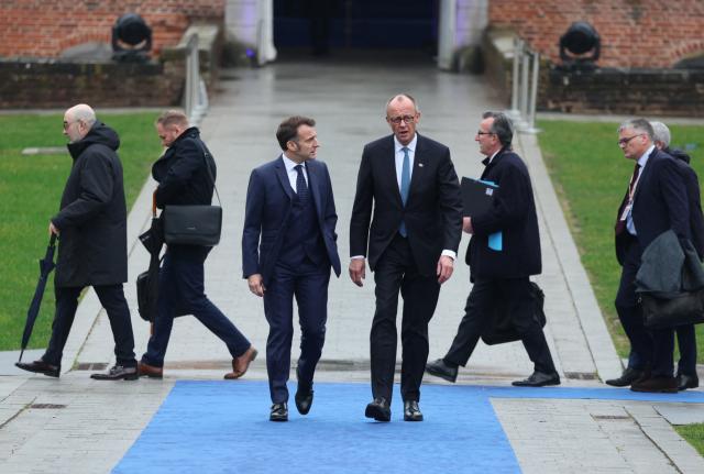 France's President Emmanuel Macron (C/L) and Germany's Chancellor Friedrich Merz (C/R) arrive to attend the Informal EU Leaders' Retreat at the Alden Biesen Castle in Alden Biesen, central Belgium on February 12, 2026. (Photo by Ludovic MARIN / AFP)