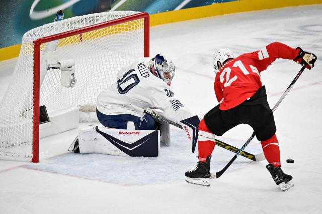 Switzerland's #21 Kevin Fiala (R) fights for the puck with France's #30 Antoine Keller during the men's preliminary round Group A Ice Hockey match between Switzerland and France at the Milano Santagiulia Ice Hockey Arena during the Milano Cortina 2026 Winter Olympic Games in Milan, on February 12, 2026. (Photo by Alexander NEMENOV / AFP)
