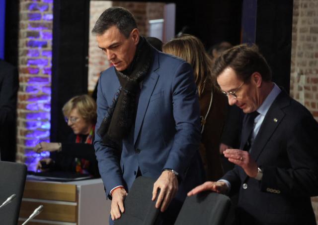 Spain's Prime Minister Pedro Sanchez (L) and Sweden's Prime Minister Ulf Kristersson attend the Informal EU Leaders' Retreat at the Alden Biesen Castle in Alden Biesen, central Belgium on February 12, 2026. (Photo by Ludovic MARIN / AFP)