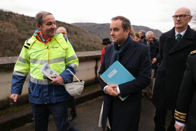 Electricite de France (EDF) CEO Bernard Fontana (L), France's Economy and Finance Roland Lescure (R) and France's Prime Minister Sebastien Lecornu (C) walk while attending a visit at the barrage de Vouglans (an hydroelectric dam), in Vouglans, eastern France on February 12, 2026. What new energy policy for France in 2035? French government approved on February 12, 2026 a stagnation in electricity consumption, which is leading it to slow down the deployment of onshore wind and solar energy, alongside a massive revival of nuclear power. (Photo by Thomas SAMSON / AFP)