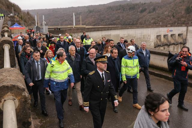 Prefect of the Jura department Pierre-Edouard Colliex (L) and France's Prime Minister Sebastien Lecornu (C) walk while attending a visit at the barrage de Vouglans (an hydroelectric dam), in Vouglans, eastern France on February 12, 2026. What new energy policy for France in 2035? French government approved on February 12, 2026 a stagnation in electricity consumption, which is leading it to slow down the deployment of onshore wind and solar energy, alongside a massive revival of nuclear power. (Photo by Thomas SAMSON / AFP)