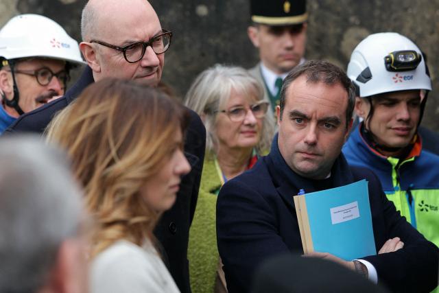 France's Economy and Finance Roland Lescure (2nd-L|) and France's Prime Minister Sebastien Lecornu (C) listen to explanations while attending a visit at the barrage de Vouglans (an hydroelectric dam), in Vouglans, eastern France on February 12, 2026. What new energy policy for France in 2035? French government approved on February 12, 2026 a stagnation in electricity consumption, which is leading it to slow down the deployment of onshore wind and solar energy, alongside a massive revival of nuclear power. (Photo by Thomas SAMSON / AFP)