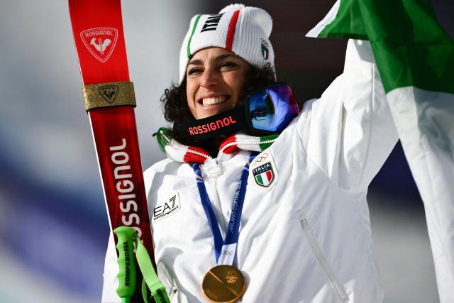 Italy's gold medalist Federica Brignone celebrates on the podium of the women's super-G event during the Milano Cortina 2026 Winter Olympic Games at the Tofane Alpine Skiing Centre in Cortina d’Ampezzo on February 12, 2026. (Photo by Marco BERTORELLO / AFP)