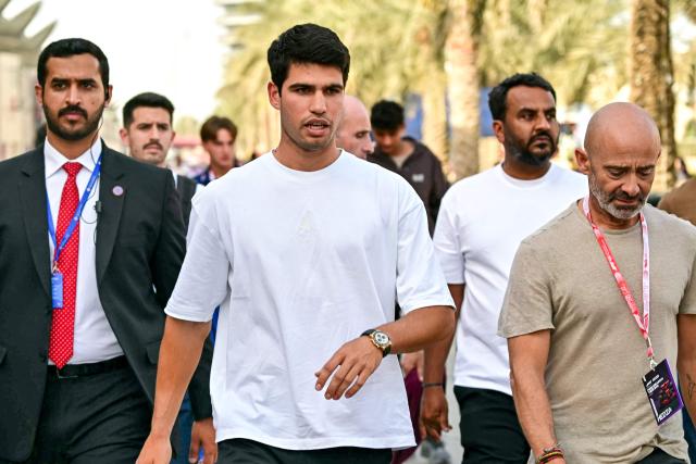 Spain's tennis player Carlos Alcaraz (C) visits the track on the second day of the Formula One pre-season testing at the Bahrain International Circuit in Sakhir on February 12, 2026. (Photo by Giuseppe CACACE / AFP)