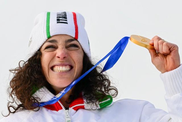Italy's gold medalist Federica Brignone celebrates on the podium of the women's super-G event during the Milano Cortina 2026 Winter Olympic Games at the Tofane Alpine Skiing Centre in Cortina d’Ampezzo on February 12, 2026. (Photo by Stefano RELLANDINI / AFP)