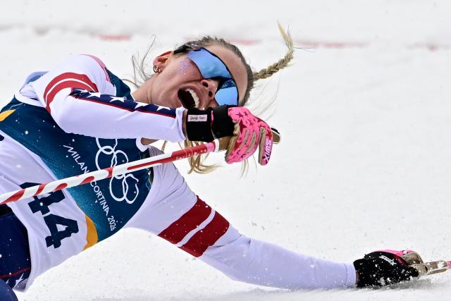 USA's Jessie Diggins collapses after crossing the finish line during the women's cross-country skiing 10km interval start free event of the Milano Cortina 2026 Winter Olympic Games at Tesero Cross-Country Skiing Stadium in Lago di Tesero (Val di Fiemme), on February 12, 2026. (Photo by Tobias SCHWARZ / AFP)