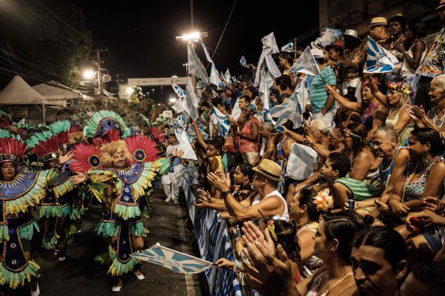 (FILES) People cheer revellers of Caprichosos de Pilares samba school (Serie B, the third division) during their parade on Intendente Magalhaes street in Rio de Janeiro, Brazil, on February 28, 2017. The samba school Caprichosos de Pilares competes in the 2026 Bronze Series of Rio de Janeiro's Carnival, the lowest division, whose parade takes place on Estrada Intendente Magalhaes, a street located about 21 kilometers away from the main Carnival venue, the Marques de Sapucai sambadrome. (Photo by Yasuyoshi Chiba / AFP)