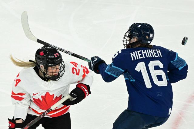 Canada's forward #24 Natalie Spooner and Finland's #16 Petra Nieminen  vie for the puck during the women's preliminary round Group A Ice Hockey match between Finland and Canada at the Milano Rho Ice Hockey Arena during the Milano Cortina 2026 Winter Olympic Games in Milan, on February 12, 2026. (Photo by Piero CRUCIATTI / AFP)