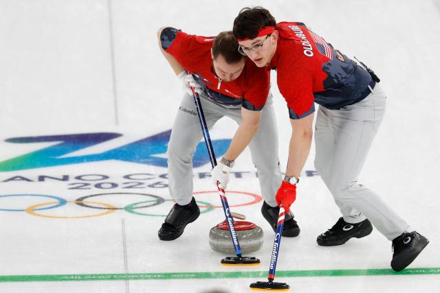 USA's Luc Violette (L) and USA's Aidan Oldenburg (R) sweep during the curling men's round robin between USA and Switzerland during the Milano Cortina 2026 Winter Olympic Games at the Cortina Curling Olympic Stadium in Cortina d’Ampezzo on February 12, 2026. (Photo by Odd ANDERSEN / AFP)