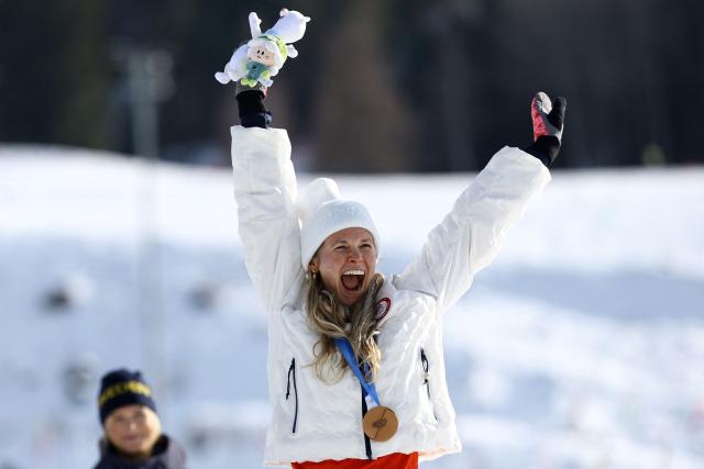 Bronze medallist USA's Jessie Diggins celebrates on the podium for the women's cross-country skiing 10km interval start free event of the Milano Cortina 2026 Winter Olympic Games at Tesero Cross-Country Skiing Stadium in Lago di Tesero (Val di Fiemme), on February 12, 2026. (Photo by Anne-Christine POUJOULAT / AFP)