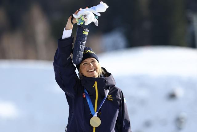 Gold medallist Sweden's Frida Karlsson celebrates on the podium for the women's cross-country skiing 10km interval start free event of the Milano Cortina 2026 Winter Olympic Games at Tesero Cross-Country Skiing Stadium in Lago di Tesero (Val di Fiemme), on February 12, 2026. (Photo by Anne-Christine POUJOULAT / AFP)
