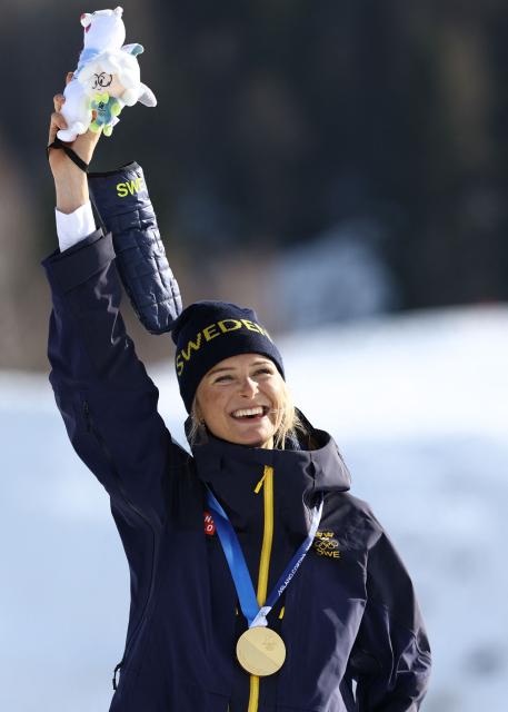 Gold medallist Sweden's Frida Karlsson celebrates on the podium for the women's cross-country skiing 10km interval start free event of the Milano Cortina 2026 Winter Olympic Games at Tesero Cross-Country Skiing Stadium in Lago di Tesero (Val di Fiemme), on February 12, 2026. (Photo by Anne-Christine POUJOULAT / AFP)