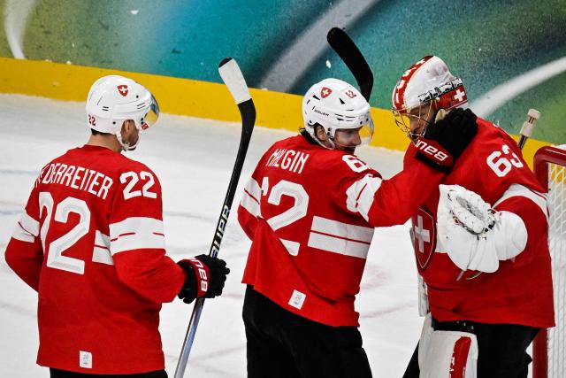(From L) Switzerland's #22 Nino Niederreiter, Switzerland's #62 Denis Malgin and Switzerland's #63 Leonardo Genoni celebrate at the end of the men's preliminary round Group A Ice Hockey match between Switzerland and France at the Milano Santagiulia Ice Hockey Arena during the Milano Cortina 2026 Winter Olympic Games in Milan, on February 12, 2026. Switzerland wins 4 - 0 against France. (Photo by Alexander NEMENOV / AFP)