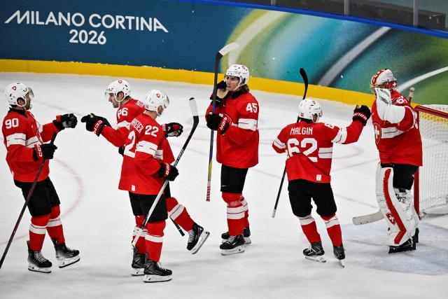 Switzerland's team players celebrate at the end of the men's preliminary round Group A Ice Hockey match between Switzerland and France at the Milano Santagiulia Ice Hockey Arena during the Milano Cortina 2026 Winter Olympic Games in Milan, on February 12, 2026. Switzerland wins 4 - 0 against France. (Photo by Alexander NEMENOV / AFP)