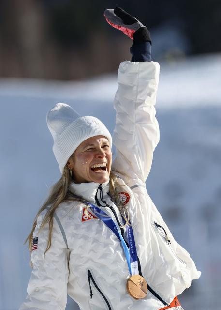 Bronze medallist USA's Jessie Diggins celebrates on the podium for the women's cross-country skiing 10km interval start free event of the Milano Cortina 2026 Winter Olympic Games at Tesero Cross-Country Skiing Stadium in Lago di Tesero (Val di Fiemme), on February 12, 2026. (Photo by Anne-Christine POUJOULAT / AFP)