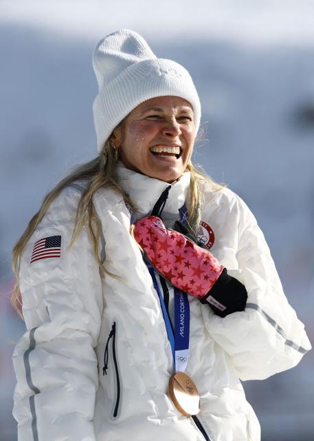 Bronze medallist USA's Jessie Diggins celebrates on the podium for the women's cross-country skiing 10km interval start free event of the Milano Cortina 2026 Winter Olympic Games at Tesero Cross-Country Skiing Stadium in Lago di Tesero (Val di Fiemme), on February 12, 2026. (Photo by Anne-Christine POUJOULAT / AFP)
