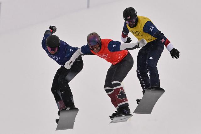 (L-R) Austria's Alessandro Haemmerle, Canada's Eliot Grondin and USA's Nick Baumgartner compete in the snowboard men's cross semi final 2 during the Milano Cortina 2026 Winter Olympic Games at Livigno Snow Park, in Livigno (Valtellina), on February 12, 2026. (Photo by Jeff PACHOUD / AFP)