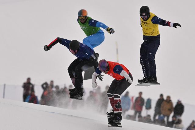 (L-R) Austria's Alessandro Haemmerle, Italy's Lorenzo Sommariva, Canada's Eliot Grondin and USA's Nick Baumgartner compete in the snowboard men's cross semi final 2 during the Milano Cortina 2026 Winter Olympic Games at Livigno Snow Park, in Livigno (Valtellina), on February 12, 2026. (Photo by Jeff PACHOUD / AFP)