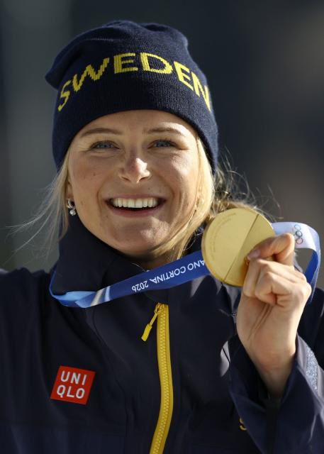 Gold medallist Sweden's Frida Karlsson celebrates on the podium for the women's cross-country skiing 10km interval start free event of the Milano Cortina 2026 Winter Olympic Games at Tesero Cross-Country Skiing Stadium in Lago di Tesero (Val di Fiemme), on February 12, 2026. (Photo by Anne-Christine POUJOULAT / AFP)