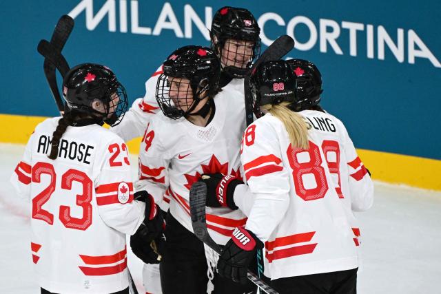 Canada's forward #94 Jennifer Gardiner celebrates with teammates after scoring during the women's preliminary round Group A Ice Hockey match between Finland and Canada at the Milano Rho Ice Hockey Arena during the Milano Cortina 2026 Winter Olympic Games in Milan, on February 12, 2026. (Photo by Piero CRUCIATTI / AFP)