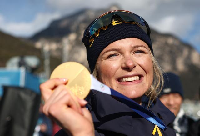 Gold medallist Sweden's Frida Karlsson celebrates with her medal after the podium ceremony for the women's cross-country skiing 10km interval start free event of the Milano Cortina 2026 Winter Olympic Games at Tesero Cross-Country Skiing Stadium in Lago di Tesero (Val di Fiemme), on February 12, 2026. (Photo by Anne-Christine POUJOULAT / AFP)