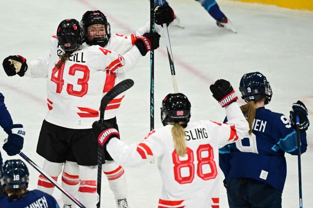 Canada's forward #94 Jennifer Gardiner celebrates with teammates after scoring during the women's preliminary round Group A Ice Hockey match between Finland and Canada at the Milano Rho Ice Hockey Arena during the Milano Cortina 2026 Winter Olympic Games in Milan, on February 12, 2026. (Photo by Piero CRUCIATTI / AFP)