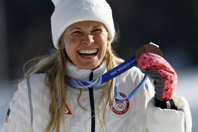 Bronze medallist USA's Jessie Diggins celebrates on the podium for the women's cross-country skiing 10km interval start free event of the Milano Cortina 2026 Winter Olympic Games at Tesero Cross-Country Skiing Stadium in Lago di Tesero (Val di Fiemme), on February 12, 2026. (Photo by Anne-Christine POUJOULAT / AFP)